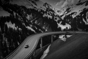 Car driving on highway surrounded by snowy mountains